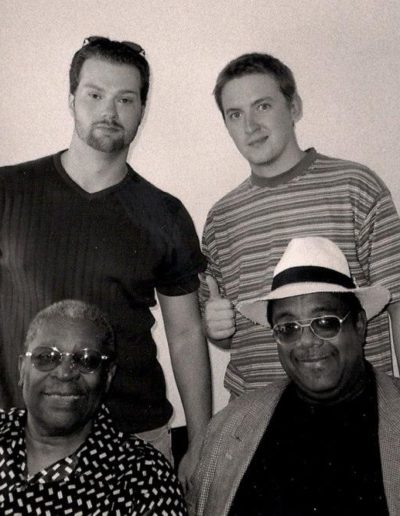 Kevin D. Stroud (young man in striped shirt top right) with famous blues artist BB King (man in patterned shirt bottom left).