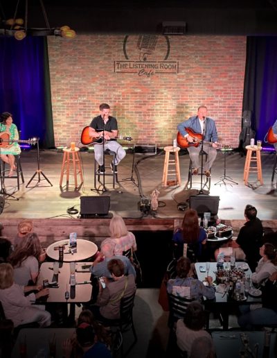 Songwriters with acoustic guitars on stage