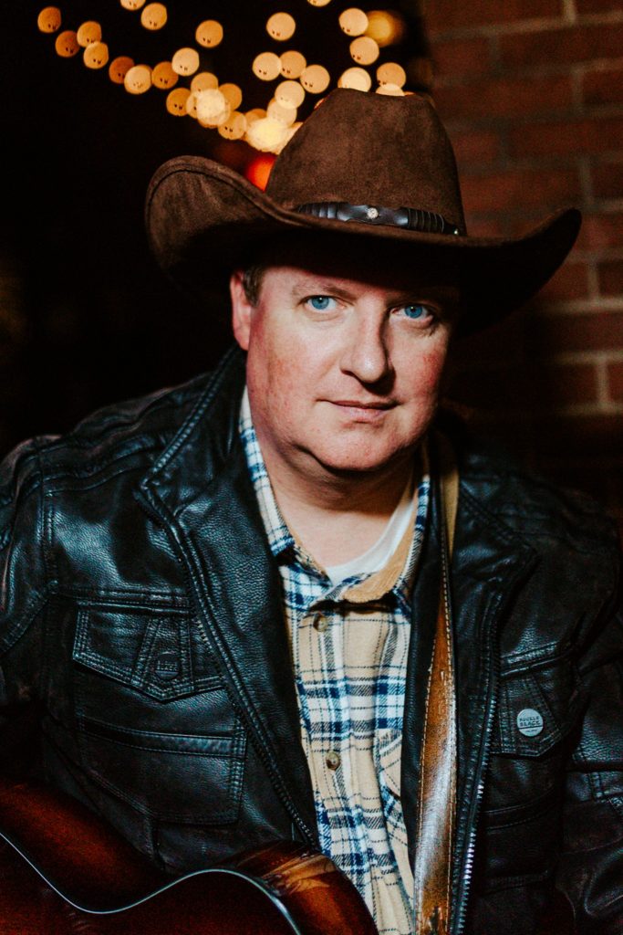 Kevin Stroud in Cowboy hat with guitar